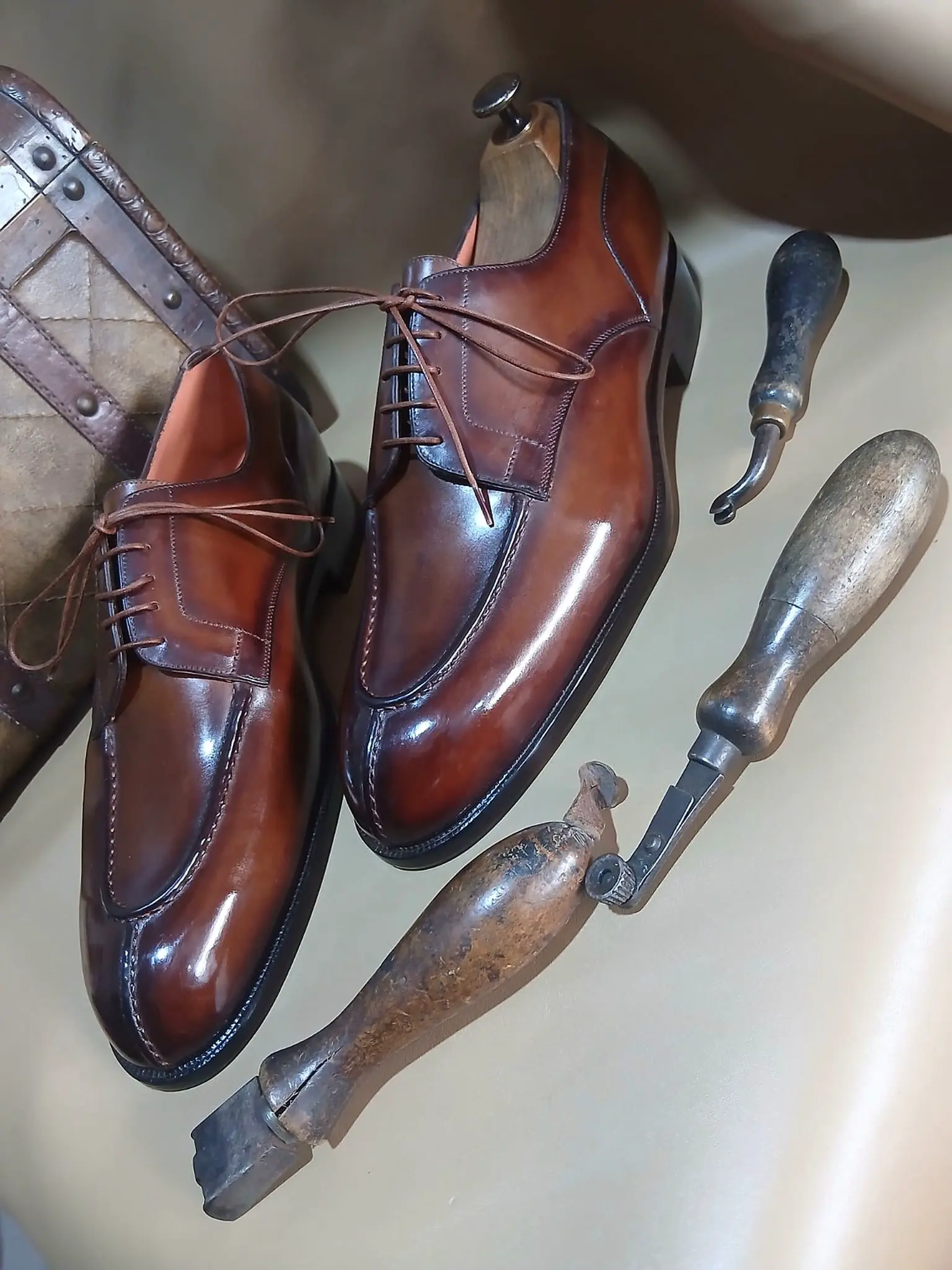 Derbies cognac patinées, à côté des outils de l'atelier