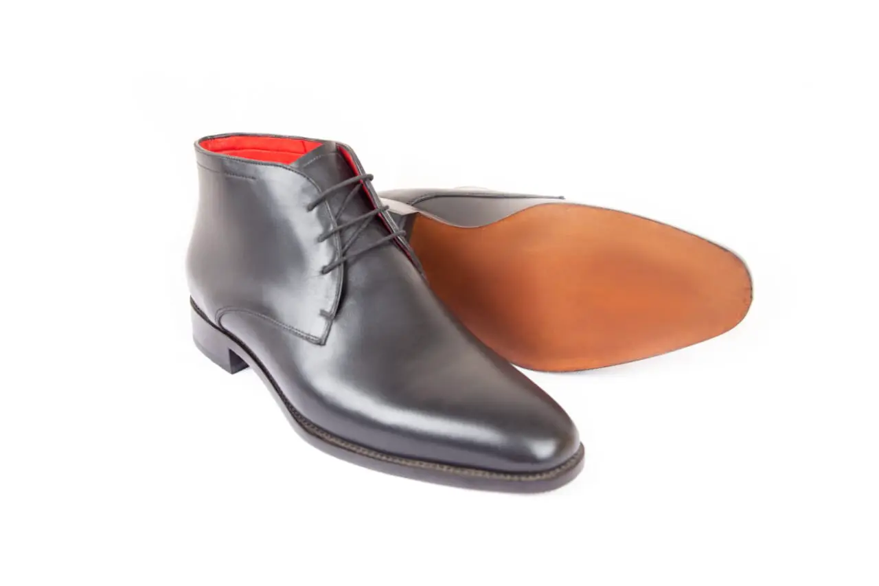 Bottines noires lacées, doublure rouge et semelle cuir
